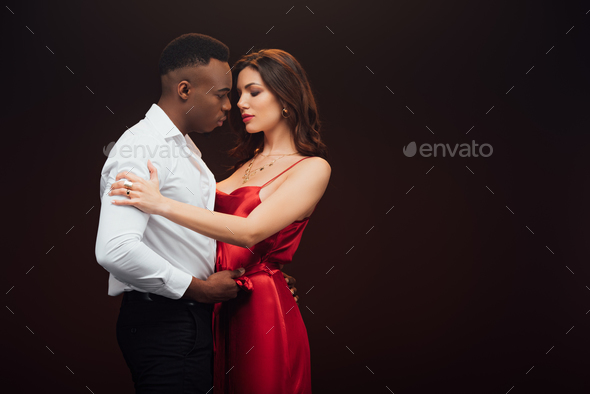 Beautiful Interracial Couple In Formal Wear Embracing Isolated On Black