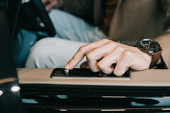 cropped view of man pushing door button in automobile