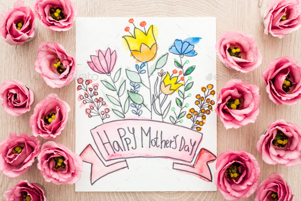 top view of eustoma flowers and card with happy mothers day writing on table