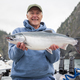 Selective focus view of a happy senior fisherman holding up a nice silver salmon in Alaska - PhotoDune Item for Sale