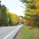 Camper drives along a Minnesota highway lined with trees in autumn color - PhotoDune Item for Sale