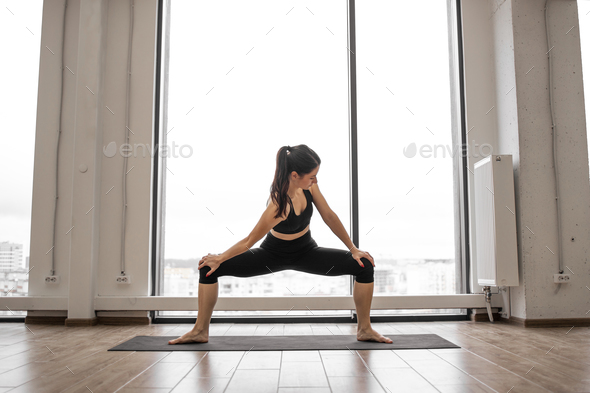 Flexible woman practising sumo squat pose