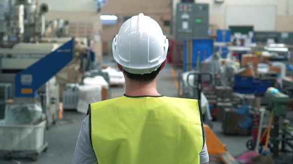Factory Worker with Safety Hard Hat Walking Through Industrial Facilities alt