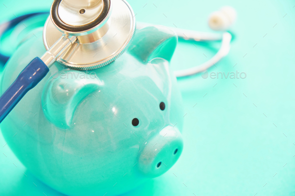 piggy bank and stethoscope on blue background, concept of medical expenses. bankrupt resuscitation