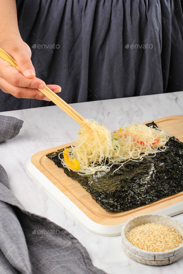 Female Home Maker Put Japcahe Stir Fry Glass Noodle on Nori Seaweed.