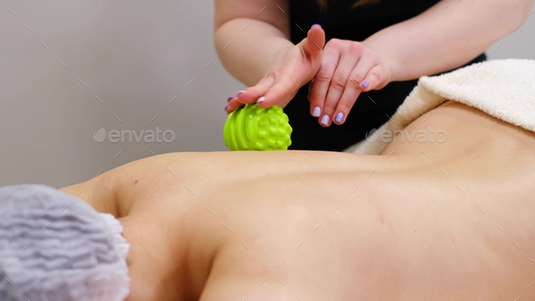 Woman at the physiotherapy receiving ball massage from therapist.