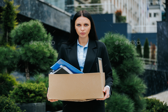 Unemployed Woman Holding Box of Belongings After Job Loss