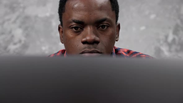 Close Up Face African American Businessman Works Laptop Chatting with Employees alt
