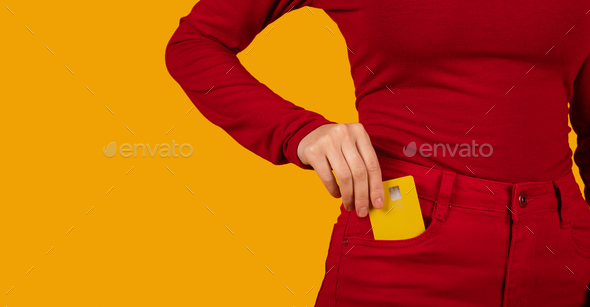 Unrecognizable woman putting yellow credit card in red pants pocket Stock  Photo by Prostock-studio