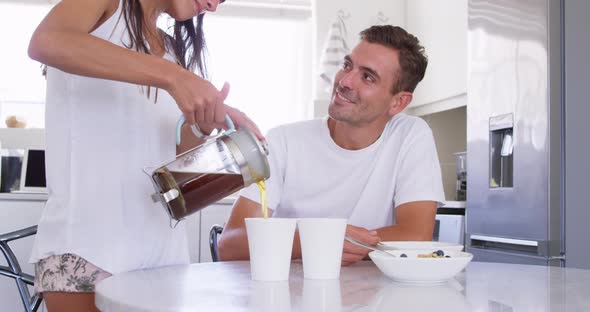 Young woman serving coffee to man on dining table at home 4k