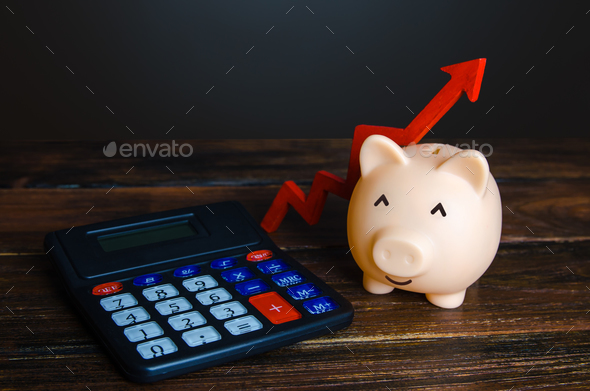 Happy piggy bank and a calculator. Growth in savings. - Stock Photo - Images