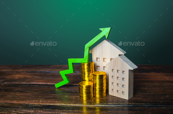 Green arrow up over wooden houses. Increasing cost of housing concept.  - Stock Photo - Images