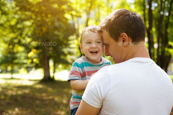 Dad plays with his little son in the park outdoors.  - Stock Photo - Images