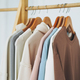 Сotton tops sweatshirts in natural tones on wooden shelf in bright room - PhotoDune Item for Sale