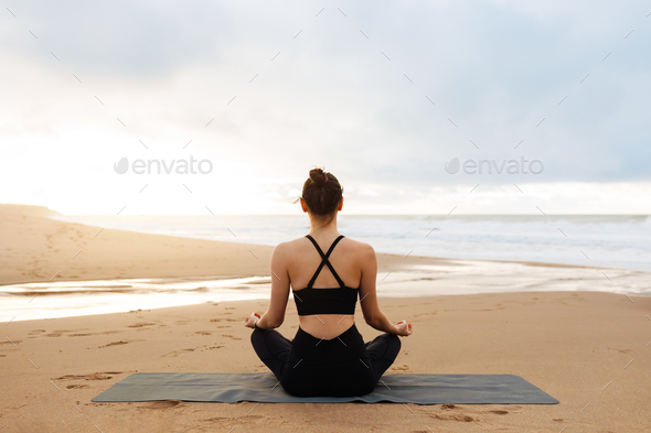 Morning meditation. Unrecognizable calm woman in activewear practicing yoga outdoors, sitting on