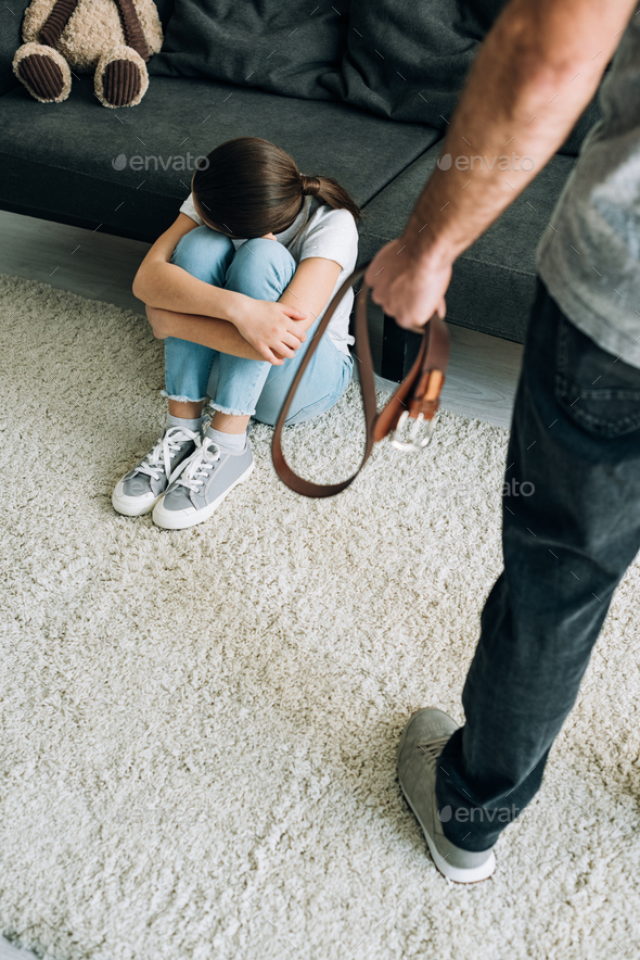 Overhead View Of Father With Belt And Daughter Sitting On Floor Stock 