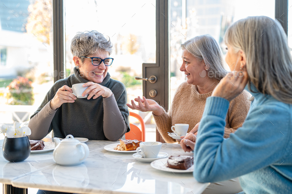 Group of elderly women having fun during breakfast in a cafeteria