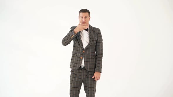 talented showman is holding his hand in front of his face and showing sad and funny emotions alt