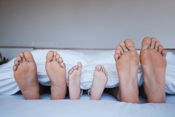 Family feet, bed and home together with love, support and bonding in the morning. Sleep, bedroom an