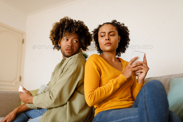 Cheating Couple Peeking At Cellphones Texting And Suspecting Unfaithfulness Indoor