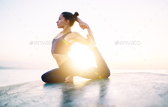 Woman doing Pigeon pose concentrated on training muscles and pilates practice