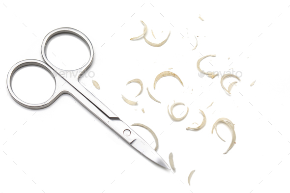 Manicure scissors and nail clipping on white background