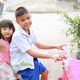 Portrait image. Happy Asian children siblings ride a bike at the park outdoor. They smile and laugh. - PhotoDune Item for Sale