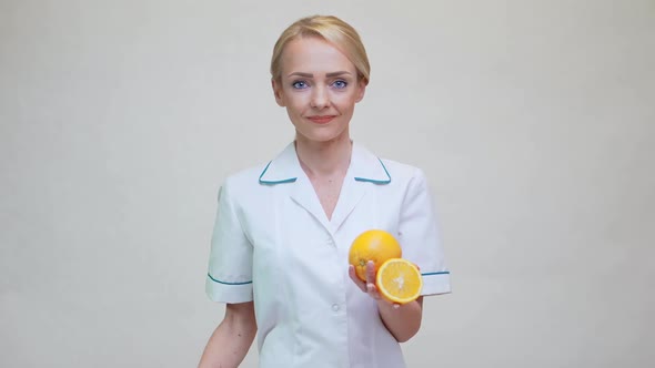 Nutritionist Doctor Healthy Lifestyle Concept - Holding Orange Fruit alt