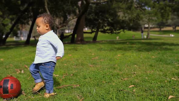 Boy Playing with Ball in Park, Trying To Playing Pass, Smiling alt
