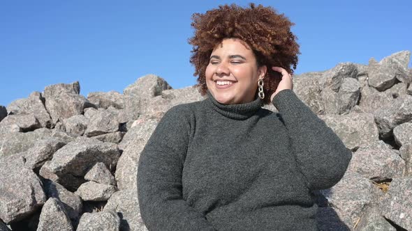 Beautiful Happy Smiling Plus Size African Black Woman Afro Hair in Grey Sweater Outdoor Enjoying