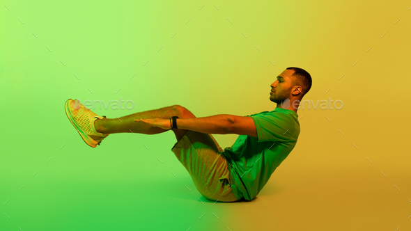 Black Sportsman Doing V Ups Abdominal Exercise Sitting Over Green