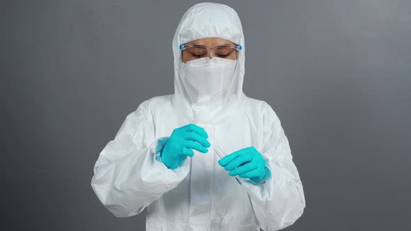 female doctor in protective suit PPE holding Coronavirus(COVID-19) Nasal swab laboratory test alt