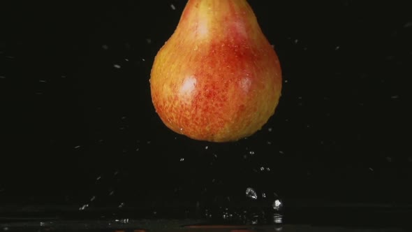 Red Pear Falls On A Black Background