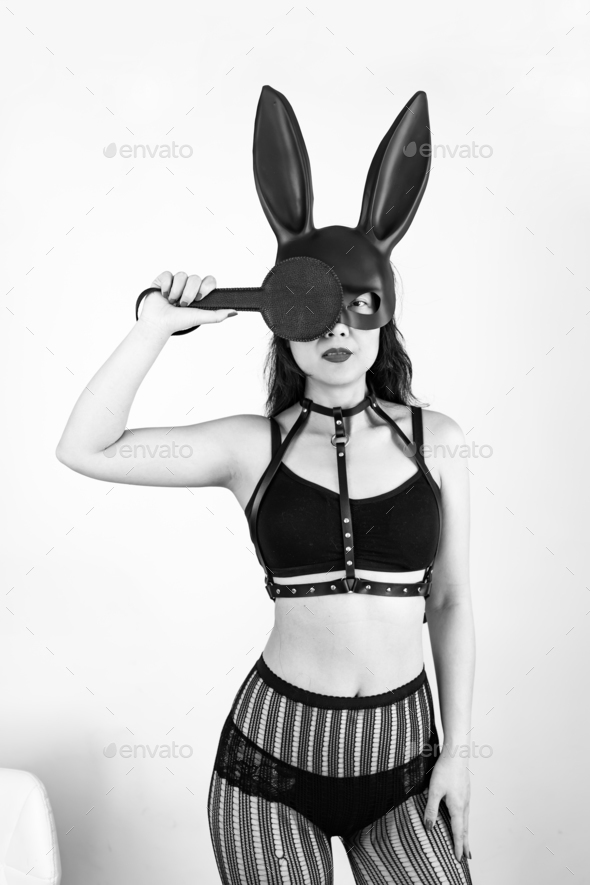 Portrait of young beautiful sexy woman with sex toys. Model wearing bdsm black mask of Easter bunny