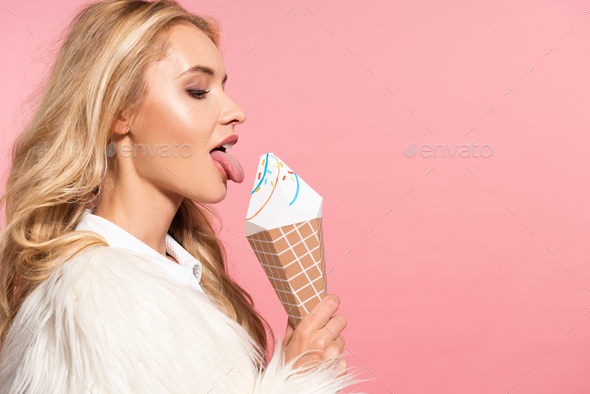 side view of beautiful sexy blonde woman in white faux fur jacket licking  decorative ice cream