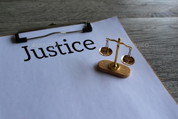 Close up image of balancing scale and text JUSTICE
