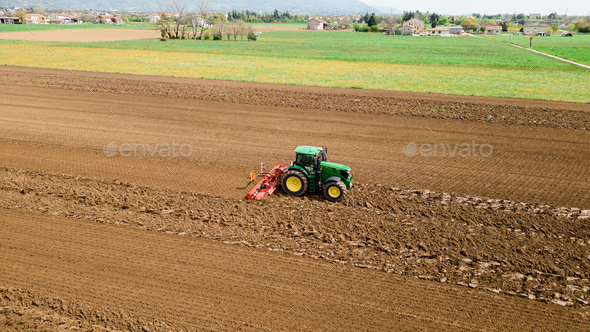 A picture of a rural farming community showcasing the use of farming machinery and equipment, such