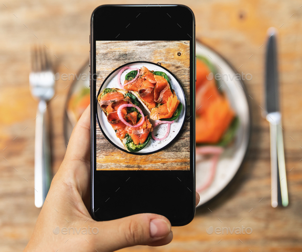 Image on smartphone screen of delicious toasts with a smoked salmon