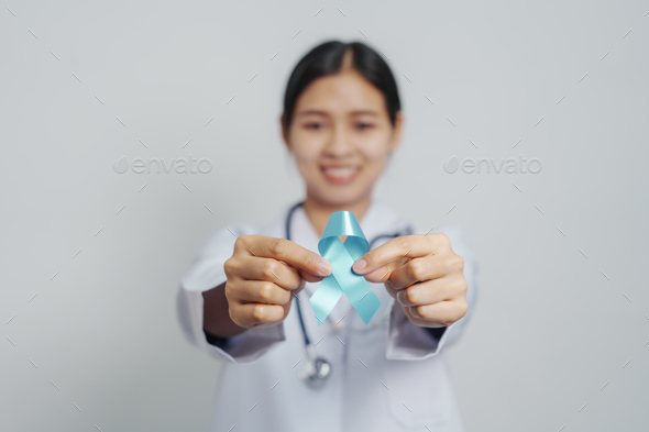 Doctor asian female specialist holding blue ribbon and stethoscope and Breast cancer awareness