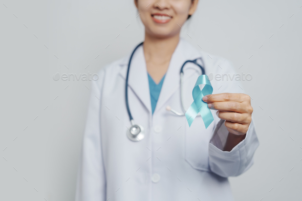 Doctor asian female specialist holding blue ribbon and stethoscope and Breast cancer awareness conce