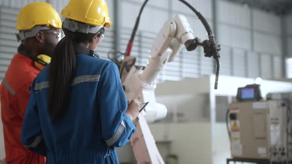 engineer cooperation male and female technician maintenance control relay robot arm system welding