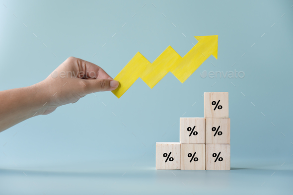Yellow paper cut arrow going up positive trend on wooden blocks with percentages