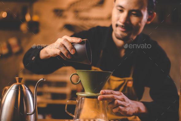 Professional barista preparing coffee using chemex pour over coffee maker  and drip kettle. Young woman making coffee. Alternative ways of brewing  coffee. Coffee shop concept. Stock Photo