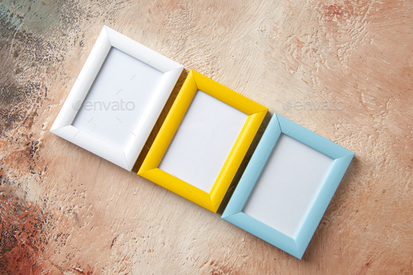 Horizontal view of colorful three photo frames hung on mix color wall