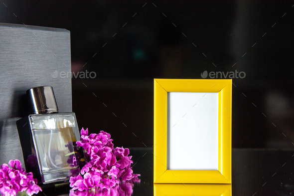 front view black fragnance with yellow picture frame on black background portrait scent color flower