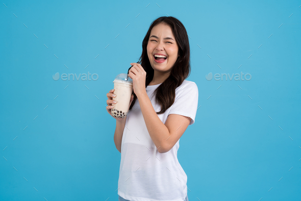 Asian girl holding a cup of pearl milk tea With a smile
