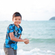 Portrait image of 8-9 years old Asian child boy playing the sand.   - PhotoDune Item for Sale