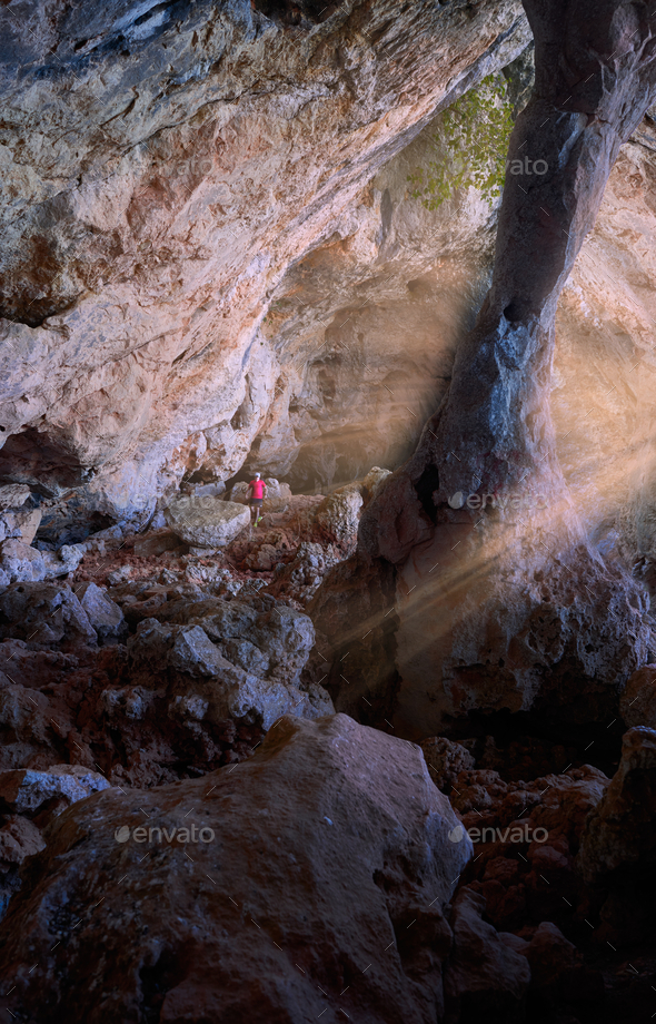 Adventurous hiker exploring the beautiful rocky caves of the mountain