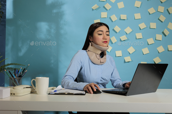 Woman with medical cervical collar at office