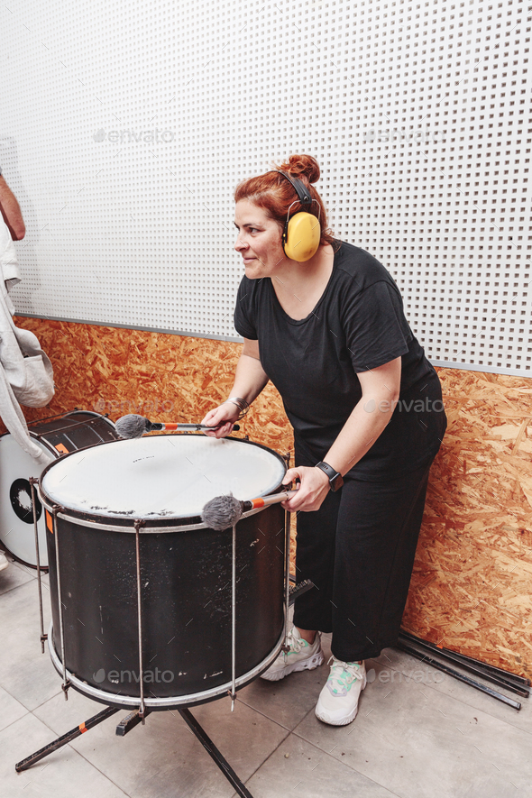 woman playing the drum with ear protections
